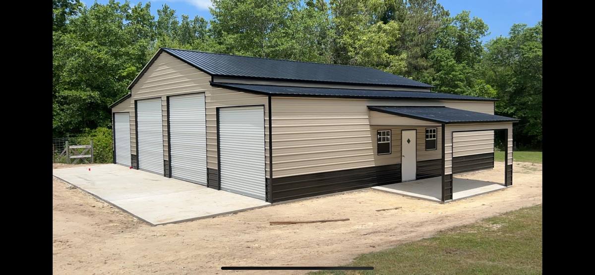 Tan and black metal garage building with lean-to and roll-up doors
